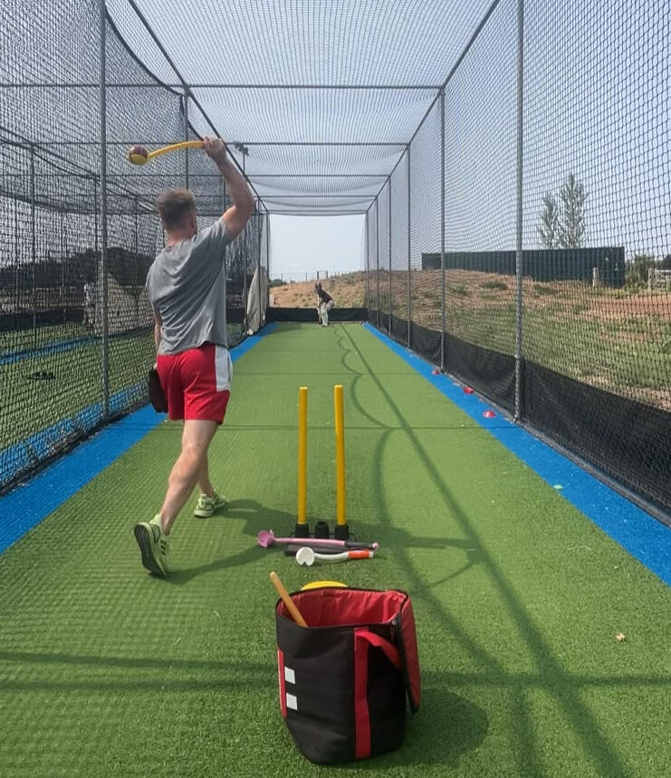 man using sidearm ball thrower for a cricket drill